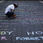 Street artist Panzarino prepares a memorial as he writes the names of the Sandy Hook Elementary School victims during the six-month anniversary of the massacre, at Union Square in New York
